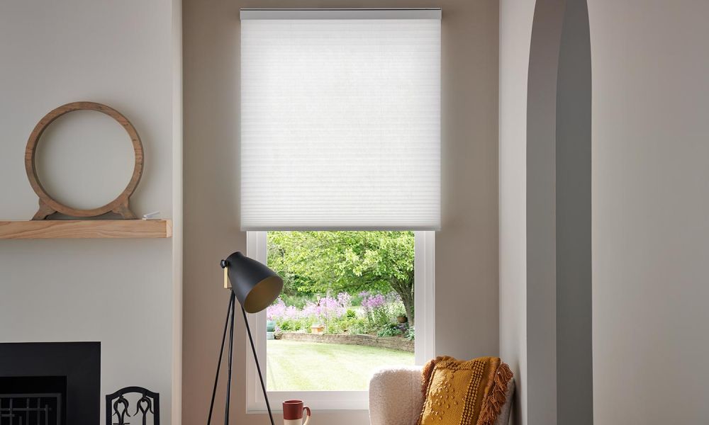 blue honeycomb shades on a window overlooking the ocean